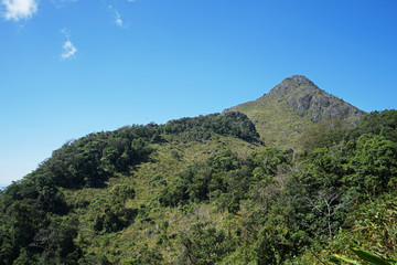 Natural landscape of rocky green mountain range view with clear blue sky