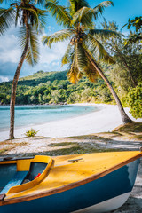 Obraz na płótnie Canvas Boat under palm trees on sunny day on tropical beach, Seychelles islands