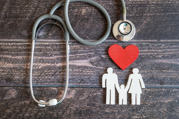 Red heart, stethoscope and icon family on wooden desk. Medical Insurance Concept