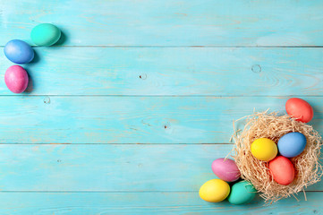 Easter concept. Colorful eggs on blue wooden background with copy space for text. Top down view or flat lay