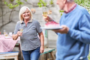 Senior couple celebrating with champagne and cake