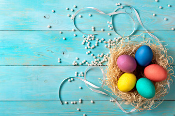 Easter concept. Colorful eggs on blue wooden background with copy space for text. Top down view or flat lay