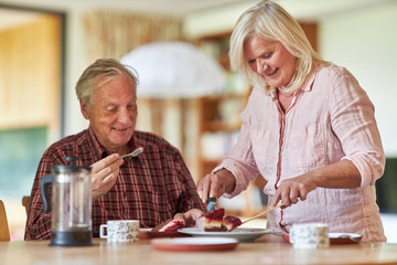 Happy seniors couple while eating cake