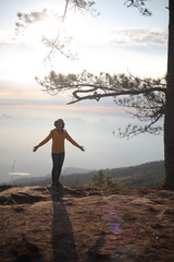 Woman standing on a cliff waiting for sunrise in Phu Kradueng National Park, Loei, Thailand