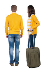 young couple in sweater traveling with suitcas.