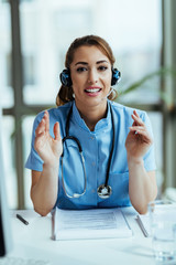 Young happy nurse working at medical hotline call center and looking at camera.