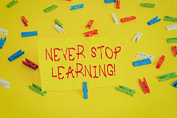 Handwriting text writing Never Stop Learning. Conceptual photo keep on studying gaining new knowledge or materials Colored clothespin papers empty reminder yellow floor background office