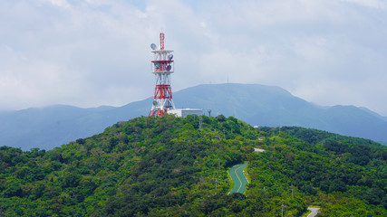  Large red white color radio antenna on top of the mountain. satellite dish on top of green mountain panorama