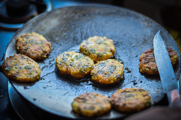 woman making a indian sweet dish on a fry pen, Indian Tikki 