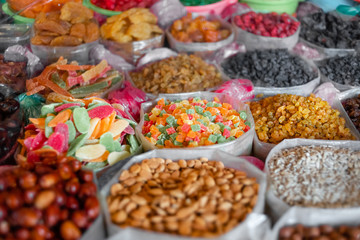 A large counter with colorful candied fruits with various pieces of fruit at La Boqueria Market..