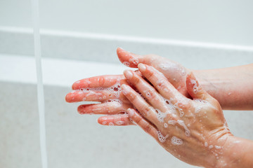 Fototapeta premium Close-up of woman washing hands with a soap.