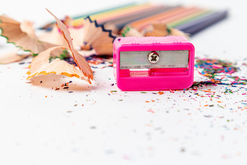 Sharpener with color pencils on white background.