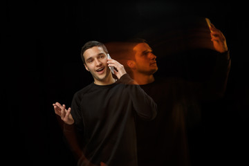 Talking outside, takes selfie inside. The versatility of man - opened emotions and hidden feelings. Caucasian man on black background with different faces of condition. Double exposure. Mental health.