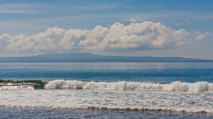 Fototapeta premium Beautiful landscape on waves of clouds and an island in the ocean.