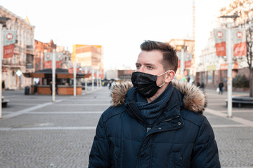 Young man in mask in empty town