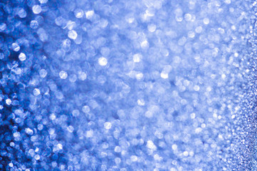 Abstract festive white to blue bokeh background with shining defocus sparkles. Blurred glitters shimmering dust macro close up, copy space for text logo