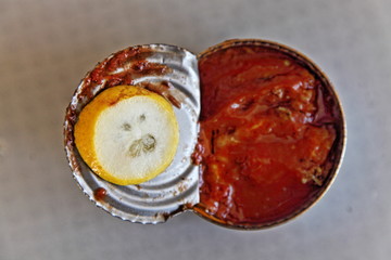 Surprised lemon slice on the lid of canned fish sprat in tomato sauce, anti-crisis food