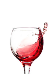 Splash of falling red wine in a round glass on a white background