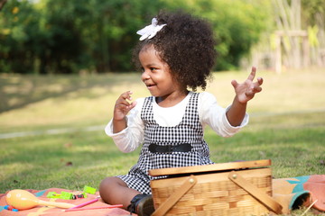 Dark skin kid play toy in the garden