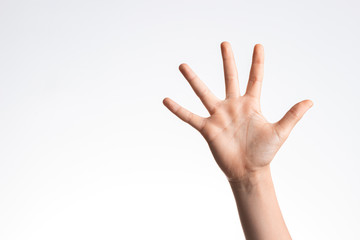 Kid hand showing and pointing up with fingers number five on white wall background