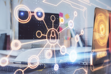 Computer on desktop with social network hologram. Multi exposure. Concept of international people connections.