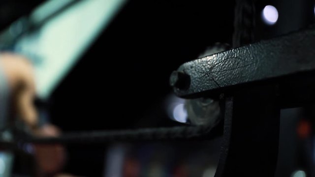 Close up of a rowing machine and a man blurry in the background, real time
