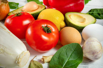 tomato, lemon, spinach, avocado, pepper, garlic, fresh vegetables and herbs on a white