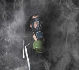 Man in a gas mask in the smoke