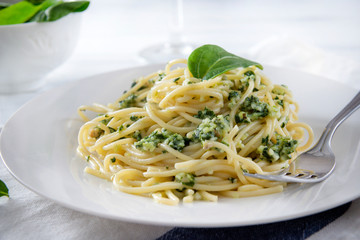 plate of pasta, spaghetti with spinach on a white wooden  close-up