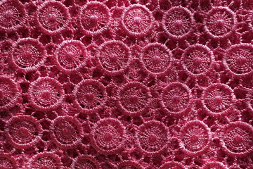 Bright pink crochet lace fabric from above