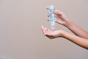 Asian girl kid using blue hand sanitizer gel in clear pump bottle , that use for killing germs, bacteria and viruses. Prevent the spread of germs and bacteria and avoid infections corona virus.