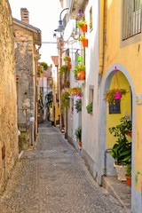 Fototapeta na wymiar A narrow street between the colorful houses of Capriati al Volturno, a village in the province of Caserta, Italy
