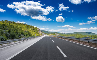 Mountain highway with blue sky and rocky mountains on a background
