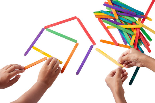 Hand of children helping each other is connecting the colorful popsicle sticks joyfully isolated on white background.