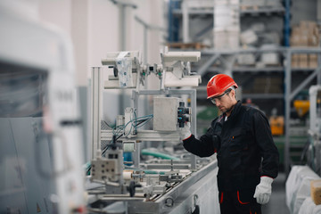 Portrait of worker in factory. Young handsome man working in factory. 