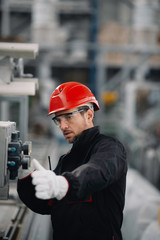 Portrait of worker in factory. Young handsome man working in factory. 