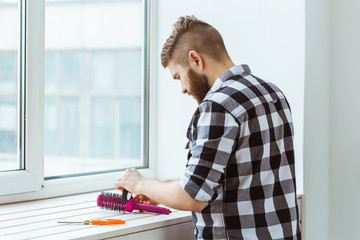 Fix and repair concept - Man working with a roll of adhesive aluminum foil tape in his hands.