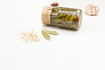 Glass jar with canned cucumbers, garlic mustard seeds.