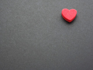Red hearts on black paper background. There is space to put text, the concept for design..