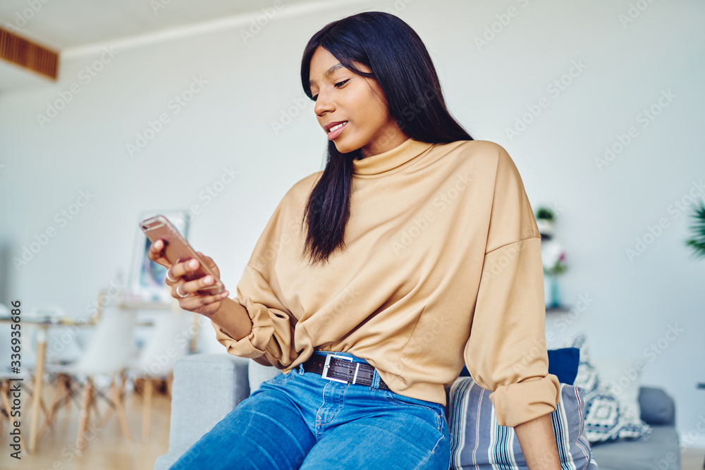 Poster pretty black female millennial typing text for sending mobile sms during web communication in own ap