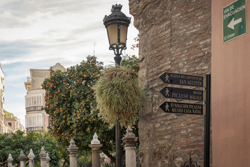 Malaga street signs directions and lamp. - obrazy, fototapety, plakaty