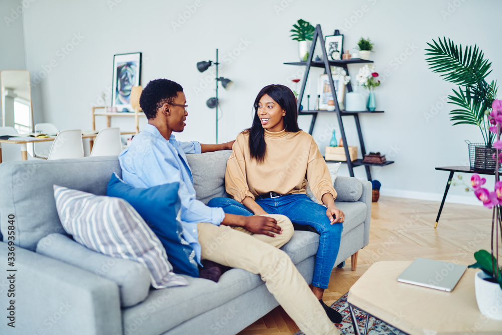 Wall mural ethnic couple talking on sofa