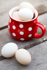 Obraz na płótnie Canvas chicken eggs in a big red cup