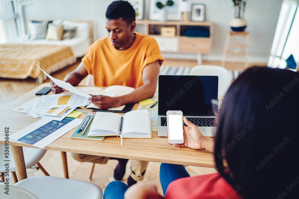 Poster back view of millennial blogger browsing website on blank smartphone with copy space area for intern