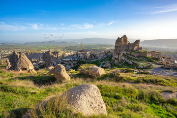 Fototapeta premium The landscape of cappadocia, Turkey. The view from the top of the hill overlooks the Uchisar Castle and this old town is a sandstone mountain. In summer, there are green grass and blue skies.