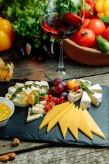 Set of cheese with honey and nuts. Slicing cheeses on a stone Board.