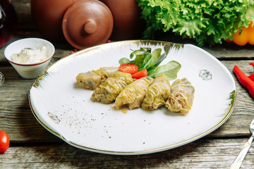 Azerbaijani restaurant dish with vegetable decor. At home on a plate with sauce and herbs.