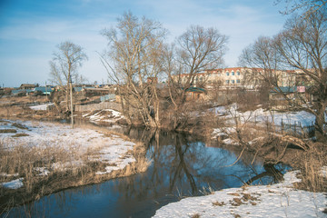 Spring river, withered grass, bare trees, remnants of snow