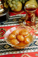 Jam of berries and ripe fruit. Restaurant dish with vegetable decor on a wooden background. Jam in a glass saucer.