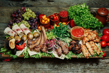  Restaurant dish with vegetable decor on a wooden background. Set of skewers with greens on a wooden Board.